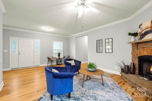 living room featuring light wood-type flooring, ornamental molding, and a fireplace