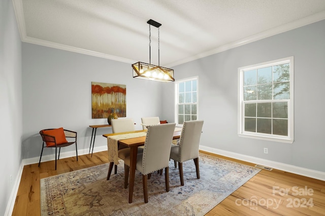 dining area with ornamental molding and hardwood / wood-style flooring