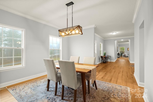 dining room featuring light hardwood / wood-style flooring and crown molding