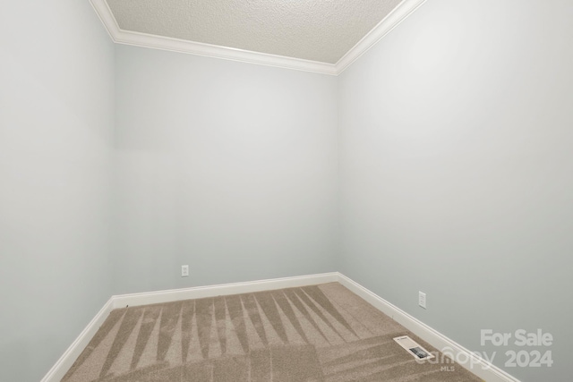 unfurnished room featuring carpet floors, a textured ceiling, and ornamental molding