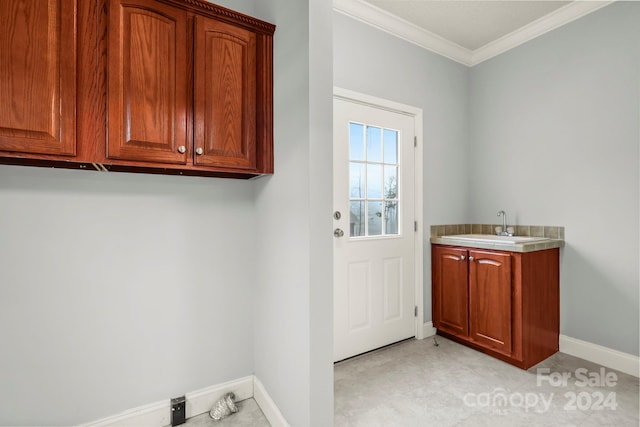 clothes washing area with ornamental molding and sink