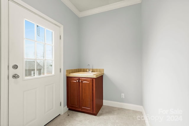 bathroom with crown molding, tile patterned flooring, and vanity