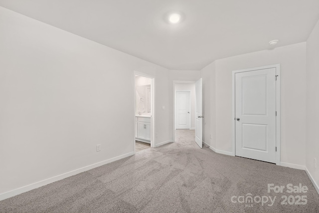 unfurnished bedroom with connected bathroom and light carpet