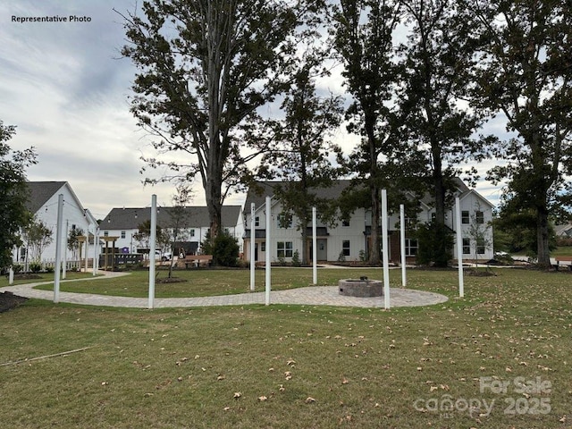 surrounding community with a fire pit and a lawn