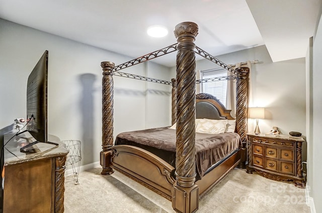 bedroom featuring light carpet and baseboards