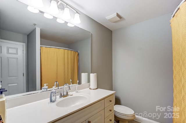 bathroom with visible vents, vanity, and toilet