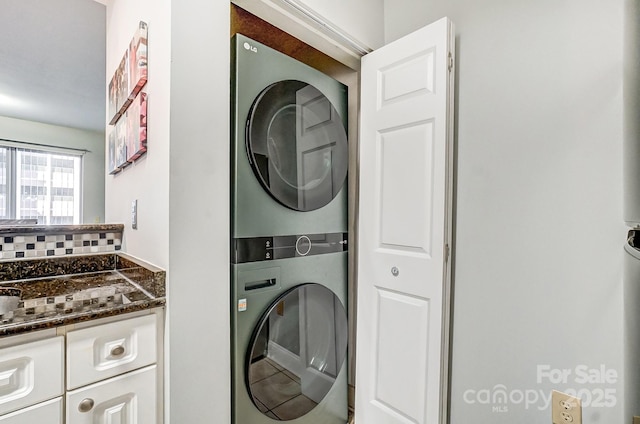 clothes washing area featuring laundry area and stacked washer / drying machine