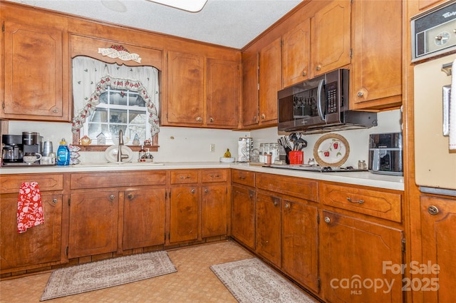 kitchen with sink, a textured ceiling, and appliances with stainless steel finishes