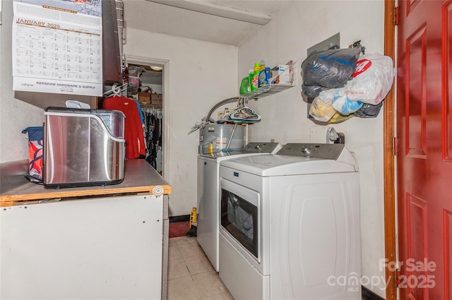 laundry area with light tile patterned floors, washing machine and dryer, and water heater