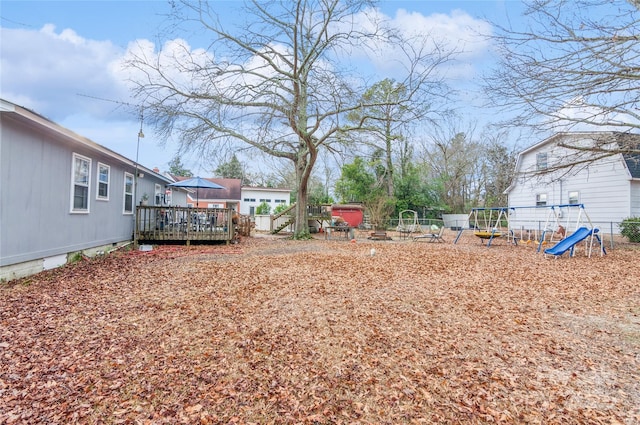 view of yard featuring a playground and a wooden deck