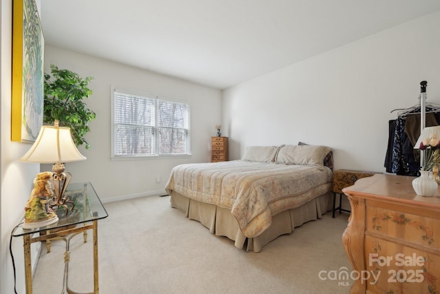 bedroom featuring light colored carpet and baseboards