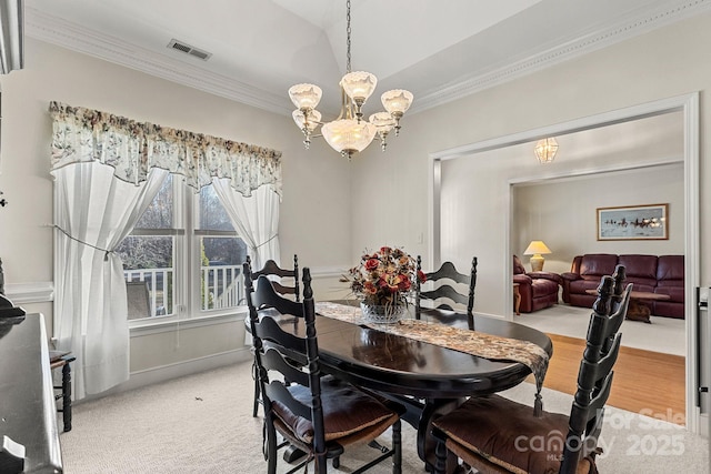 dining space featuring carpet flooring, an inviting chandelier, and crown molding