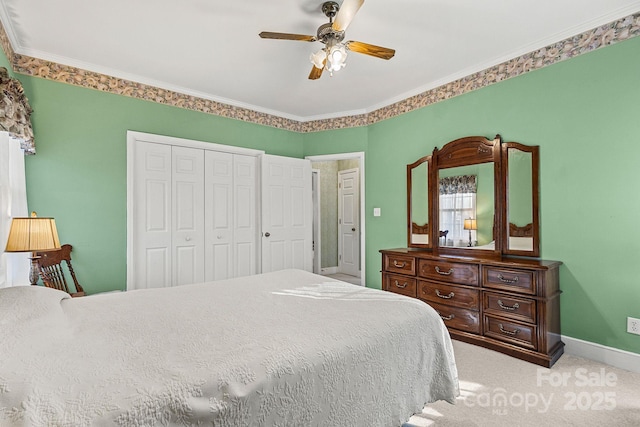 bedroom with ceiling fan, a closet, carpet, and ornamental molding