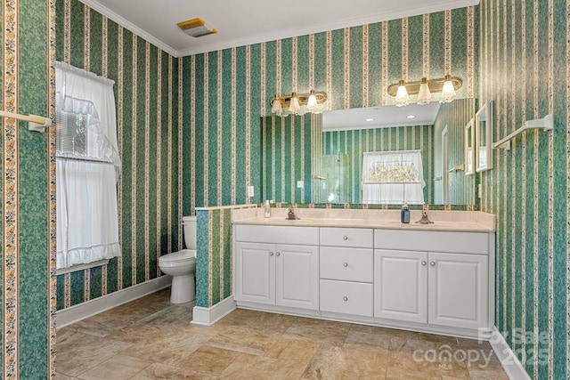 bathroom with vanity, toilet, and ornamental molding