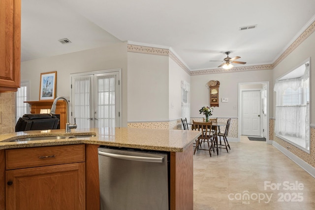 kitchen featuring dishwasher, french doors, sink, ceiling fan, and light stone counters