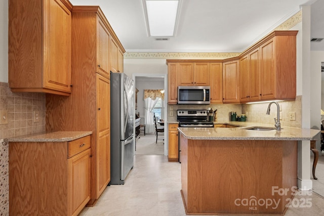 kitchen featuring kitchen peninsula, appliances with stainless steel finishes, backsplash, and sink