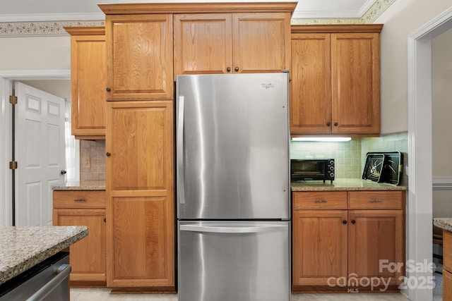 kitchen with backsplash, light stone countertops, crown molding, and stainless steel appliances