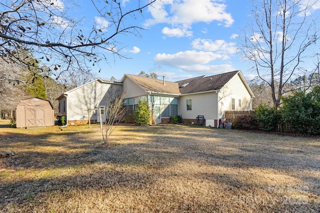 back of property with a storage shed and a yard