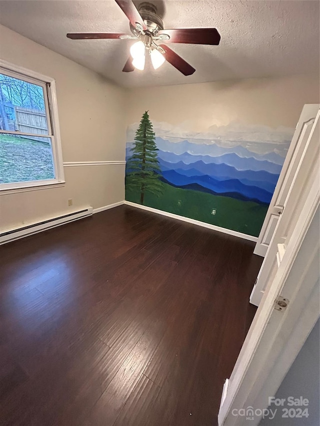 unfurnished room featuring ceiling fan, dark wood-type flooring, a textured ceiling, and a baseboard radiator