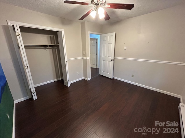 unfurnished bedroom with a textured ceiling, ceiling fan, a baseboard radiator, dark hardwood / wood-style floors, and a closet