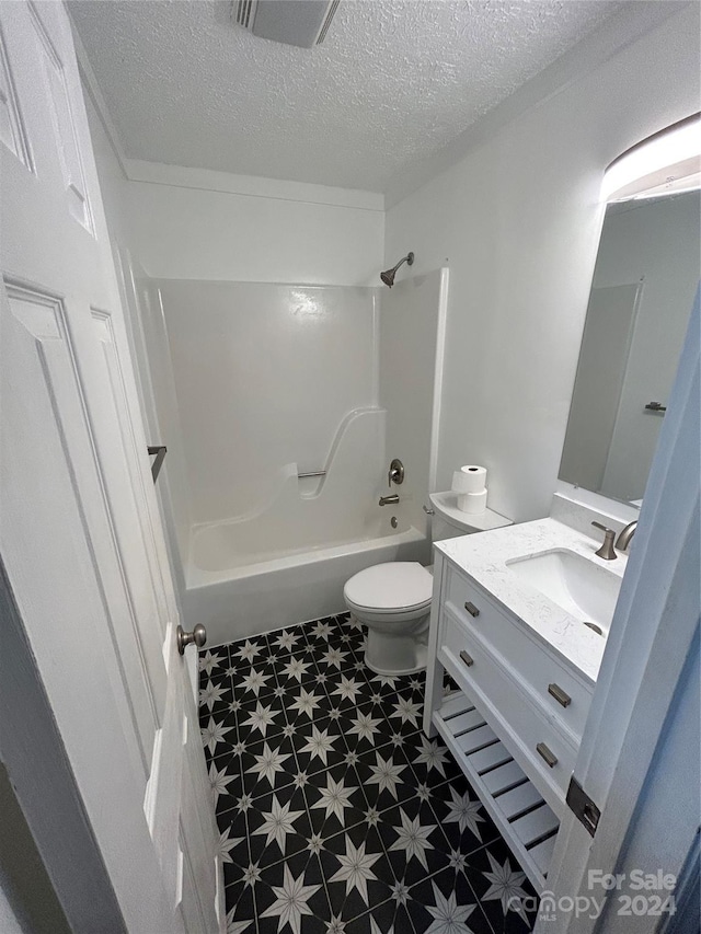 full bathroom with vanity, shower / bathtub combination, toilet, and a textured ceiling