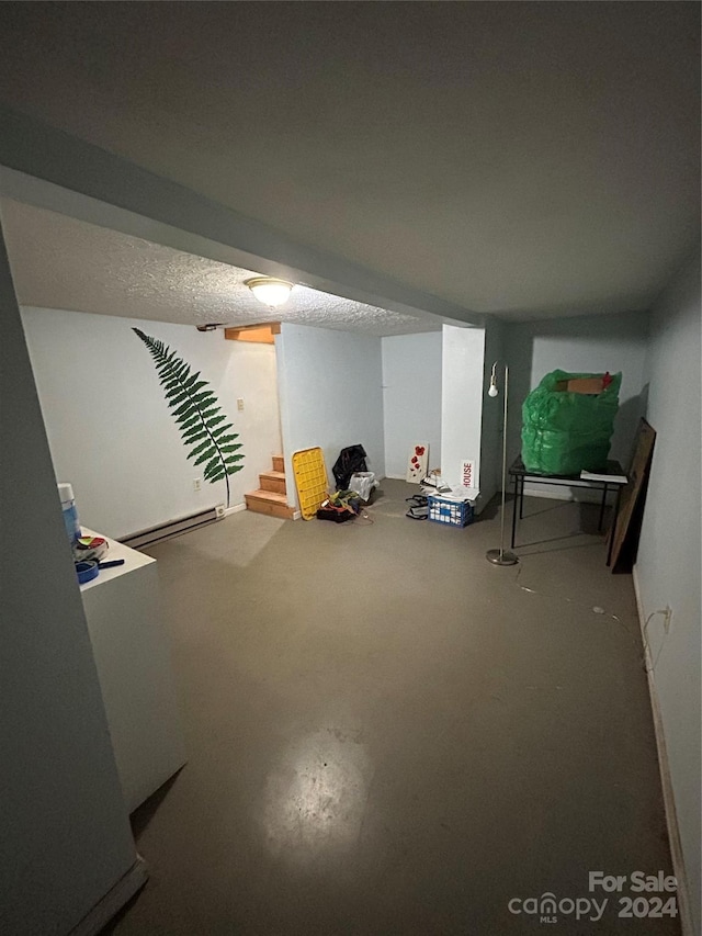 basement with a textured ceiling and a baseboard radiator