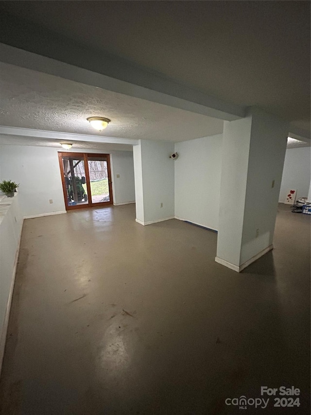 interior space with a textured ceiling and concrete floors