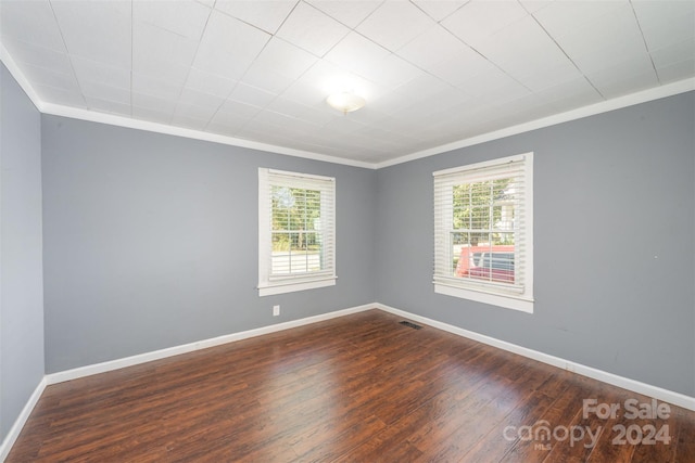 spare room with dark hardwood / wood-style flooring and ornamental molding