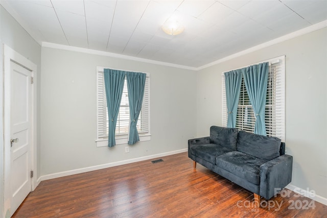 sitting room featuring ornamental molding and dark wood-type flooring