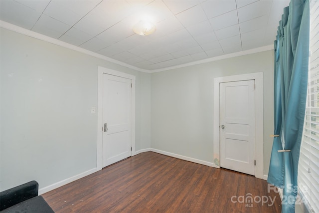 spare room with crown molding and dark hardwood / wood-style flooring