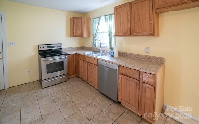 kitchen featuring appliances with stainless steel finishes, light tile patterned floors, and sink