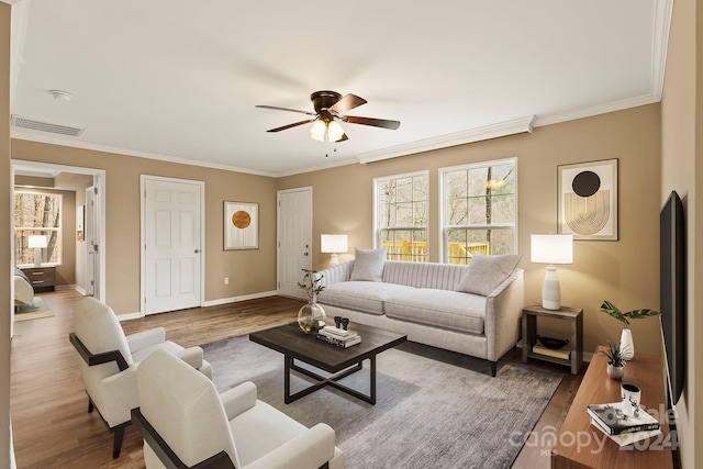 living room featuring wood-type flooring, ceiling fan, and crown molding