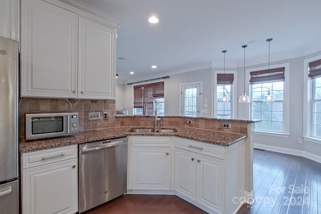 kitchen with white cabinetry, kitchen peninsula, and appliances with stainless steel finishes