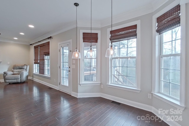 interior space featuring crown molding, plenty of natural light, and dark wood-type flooring