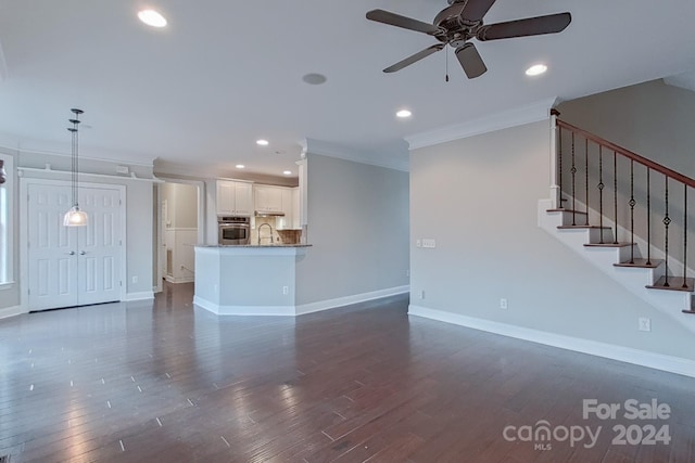 unfurnished living room with dark hardwood / wood-style flooring, ceiling fan, ornamental molding, and sink