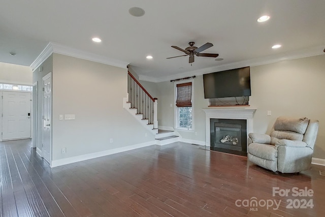 unfurnished living room featuring dark wood-type flooring, ceiling fan, and ornamental molding