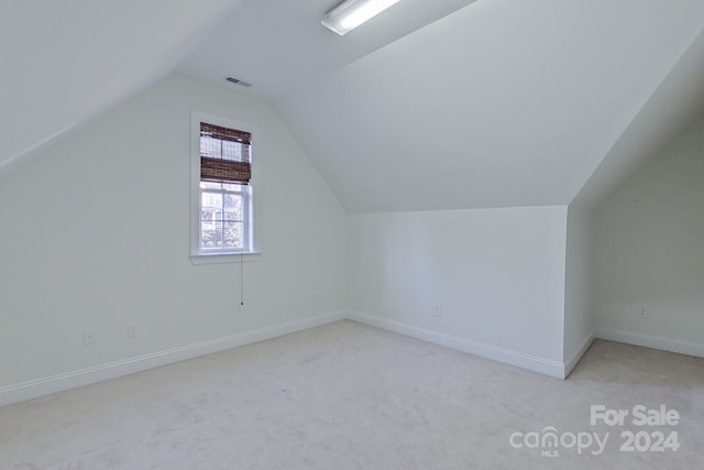 bonus room featuring light carpet and vaulted ceiling