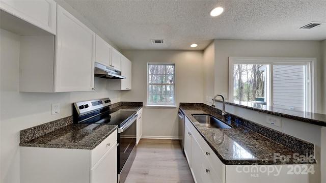 kitchen featuring dark stone counters, sink, white cabinets, and stainless steel appliances