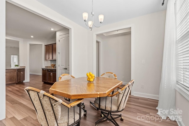 dining area featuring an inviting chandelier and light hardwood / wood-style floors