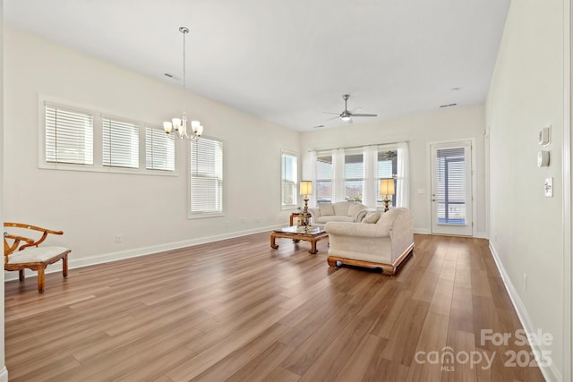 living room featuring ceiling fan with notable chandelier and hardwood / wood-style flooring