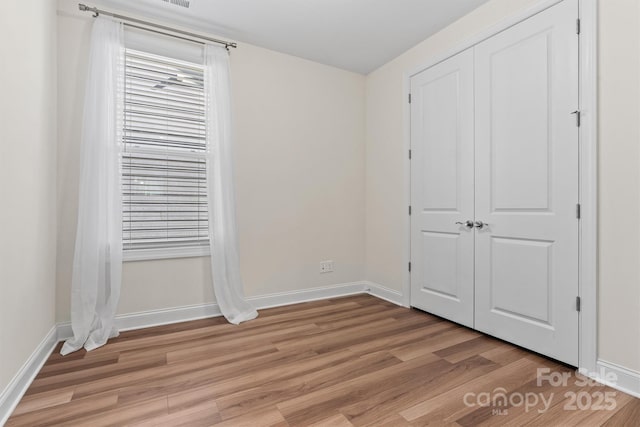 unfurnished bedroom with light wood-type flooring and a closet