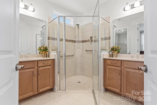 bathroom featuring a shower with door, tile patterned floors, and vanity