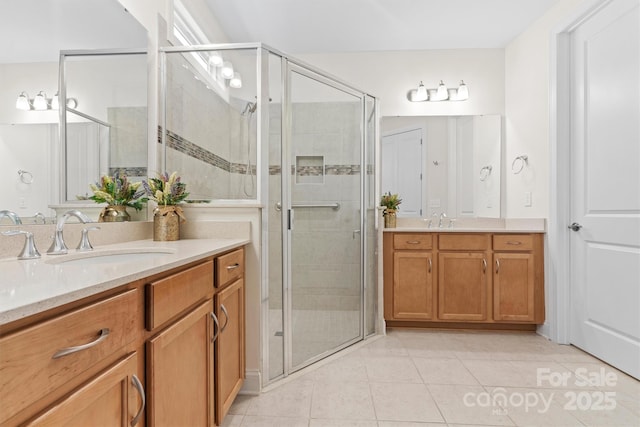 bathroom with a shower with shower door, tile patterned floors, and vanity