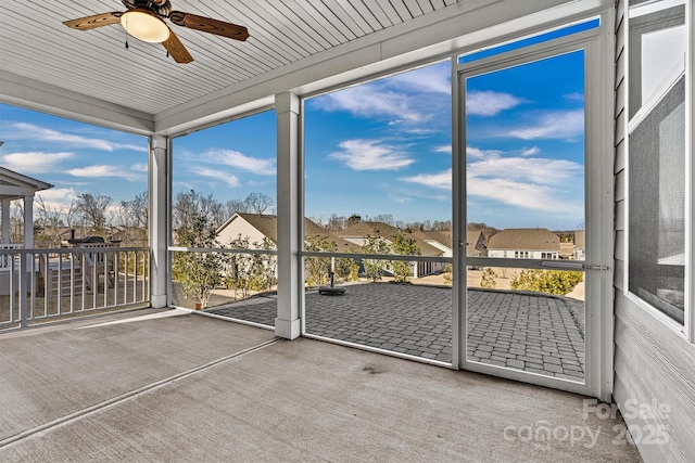 unfurnished sunroom featuring ceiling fan