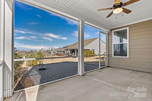 unfurnished sunroom featuring ceiling fan