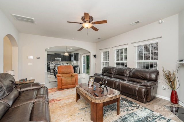 living room with ceiling fan and light wood-type flooring