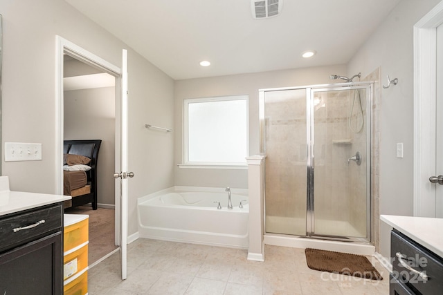 bathroom with vanity and shower with separate bathtub