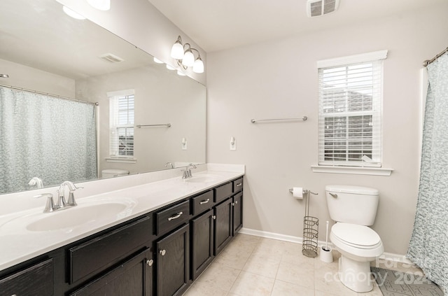 bathroom featuring tile patterned flooring, vanity, a healthy amount of sunlight, and toilet