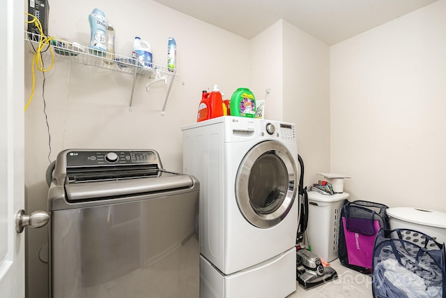 washroom featuring washer and clothes dryer and light tile patterned floors