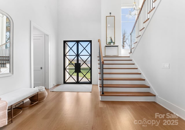 entryway featuring a high ceiling, an inviting chandelier, and light hardwood / wood-style flooring